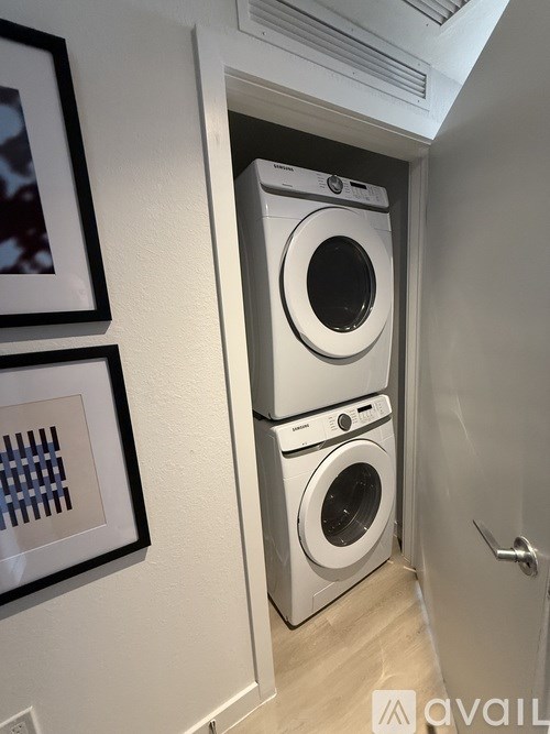A white washer and dryer stacked on top of each other in a small laundry room.