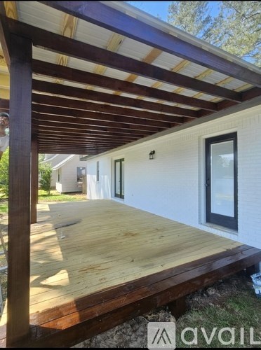 A wooden deck with a white house in the background.