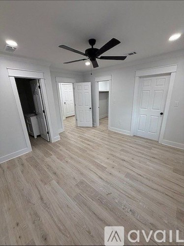 A room with a ceiling fan and wooden flooring.