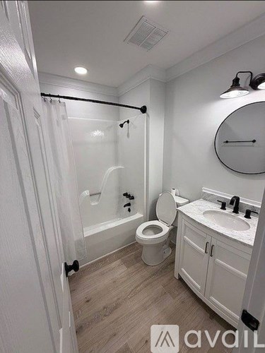 A bathroom with a toilet, sink, and shower.