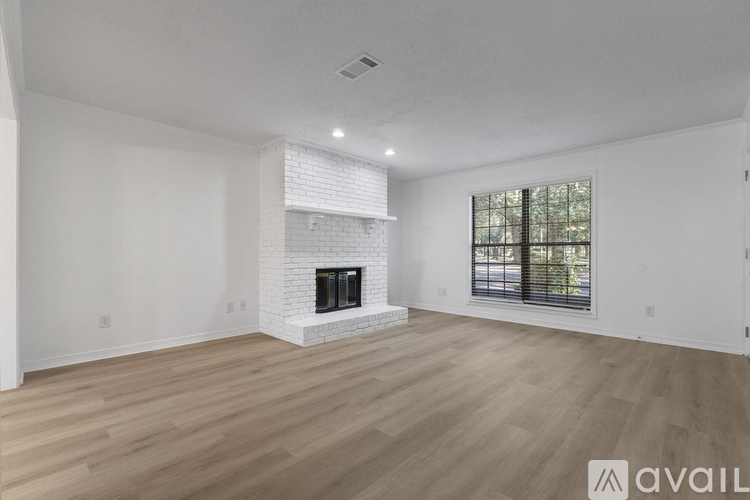 A living room with a fireplace and a ceiling fan.