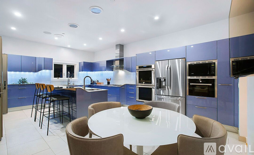 A modern kitchen with blue cabinets and a central island.