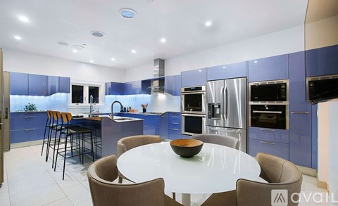 A modern kitchen with blue cabinets and a central island.