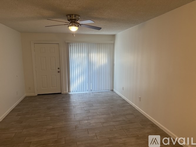 A room with a ceiling fan and a door.