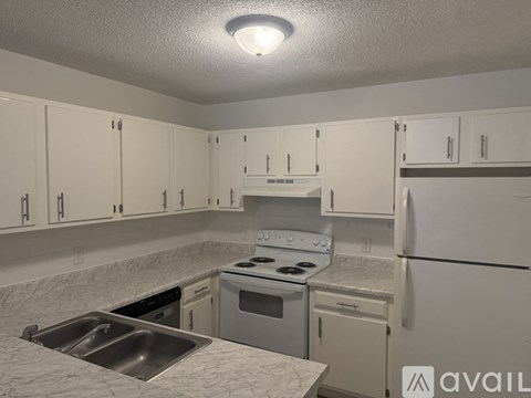 A kitchen with white cabinets and a stove top oven.
