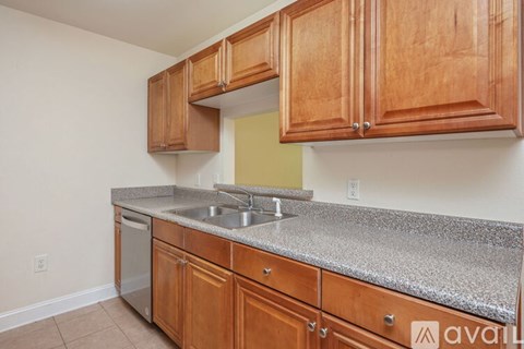 A kitchen with wooden cabinets and granite countertops.