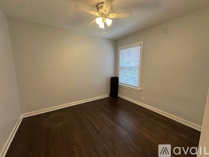 A room with wooden floors and a ceiling fan.