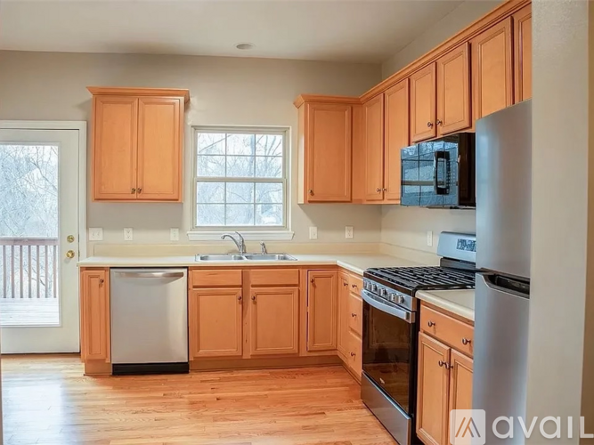 A kitchen with wooden cabinets and a stainless steel refrigerator.