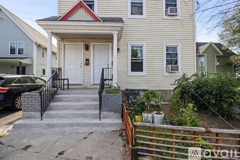 A house with a white door and a red trimmed window.