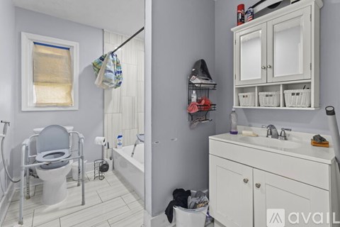 A bathroom with a toilet, sink, and a window.