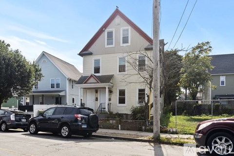 A house with a red roof and a car parked in front.