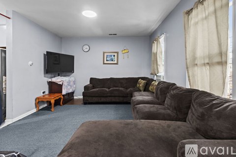 A living room with a brown couch and a flat screen TV.