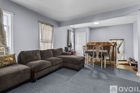 A living room with a brown sofa and a wooden table.