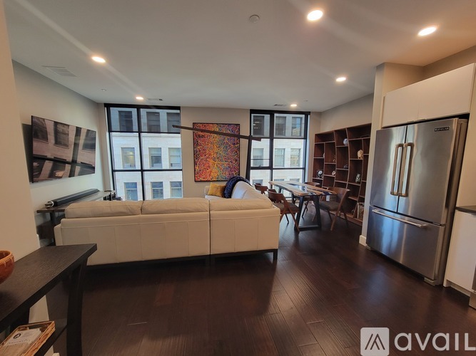 A modern kitchen with stainless steel appliances and a living area with a couch and a coffee table.