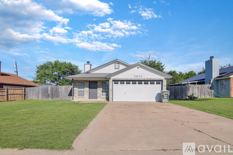 A house with a garage and a driveway in front of it.
