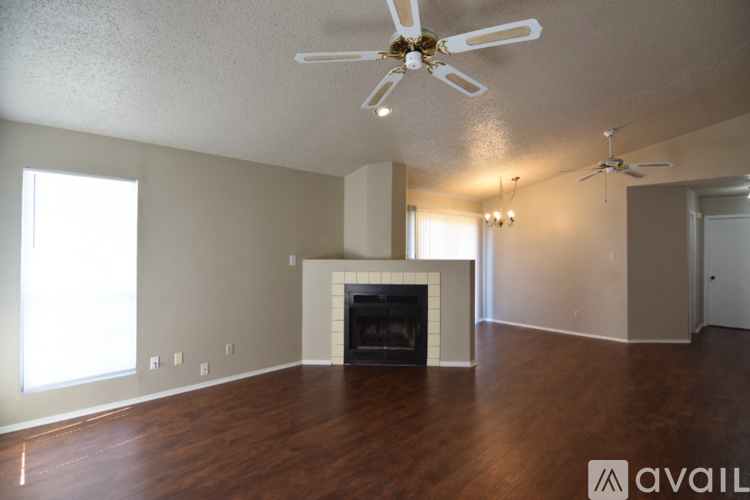 A living room with a fireplace and a ceiling fan.
