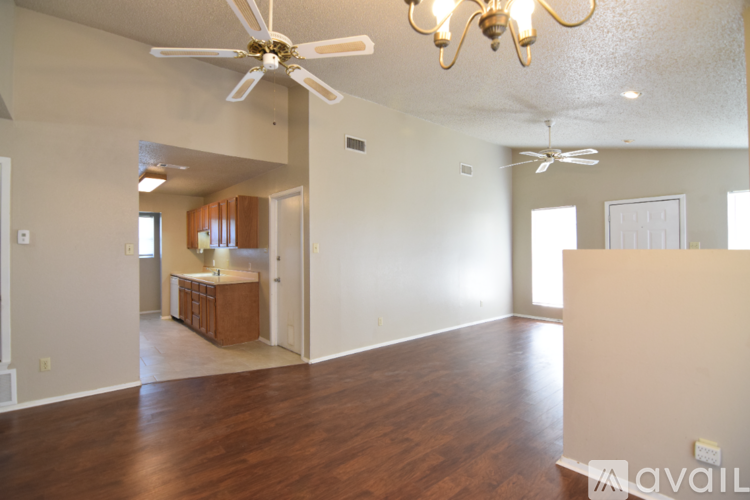 A spacious room with a ceiling fan and wooden flooring.