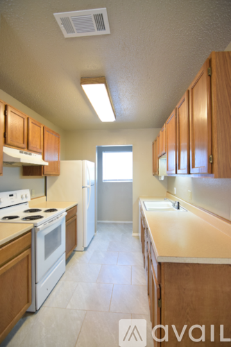 A kitchen with wooden cabinets and a white stove top oven.