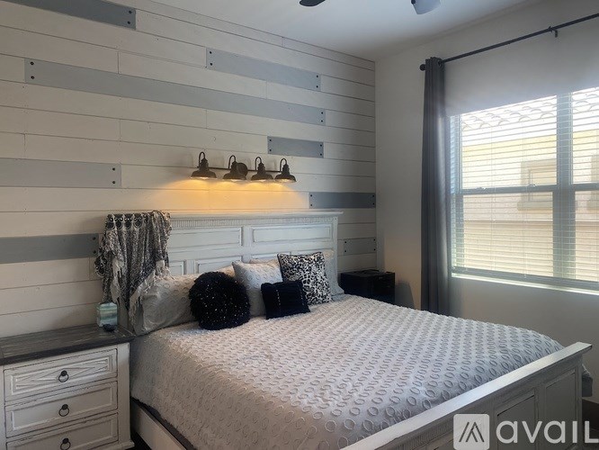 A bedroom with a bed, nightstand, and striped wall.