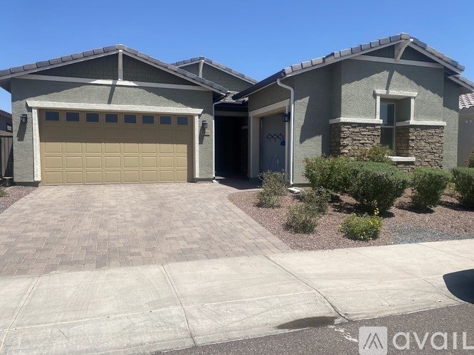 A house with a garage door and a driveway in front.