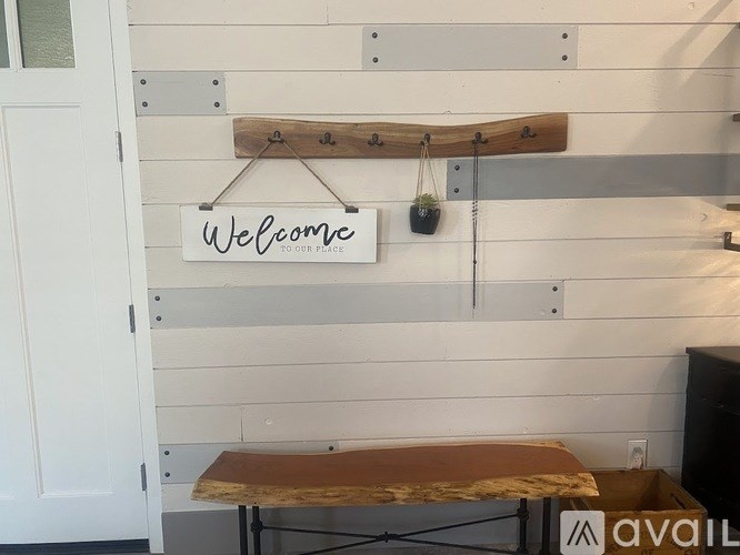 A wooden sign that says "Welcome" hangs on a wall.