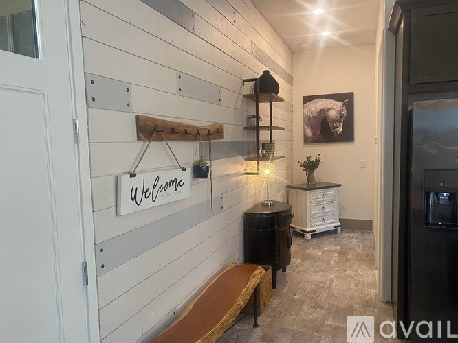 A hallway with a wooden bench and a sign that says "Welcome".