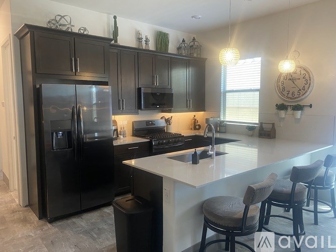 A kitchen with a black fridge and a white counter.