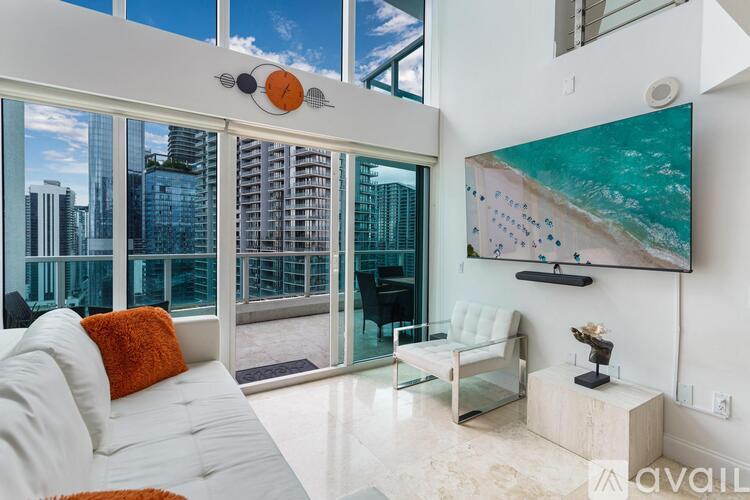 A living room with a large window overlooking a cityscape.