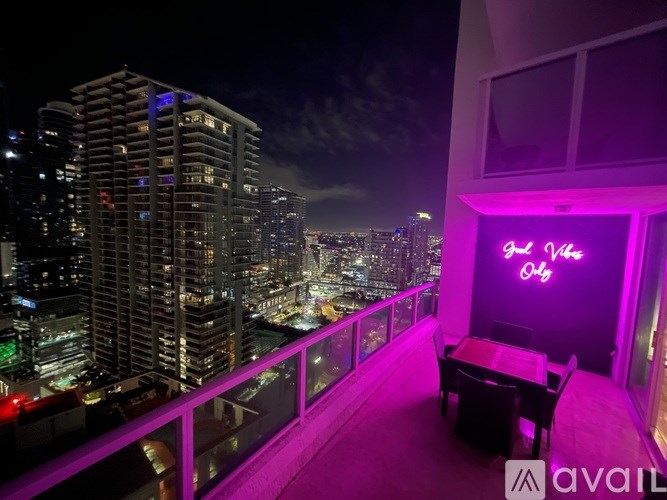 A balcony with a neon sign that says "Off" and a table and chairs.