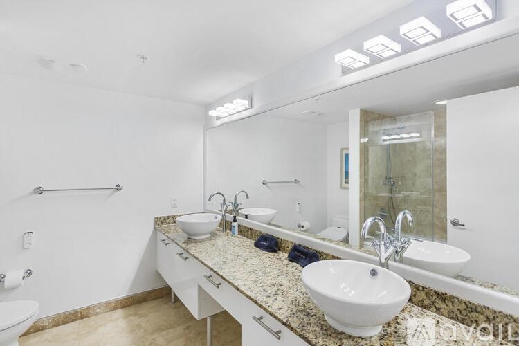A bathroom with a granite countertop and a white sink.