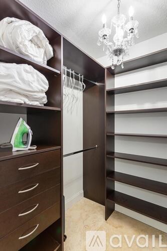 A chandelier hangs over a staircase with a striped wall.