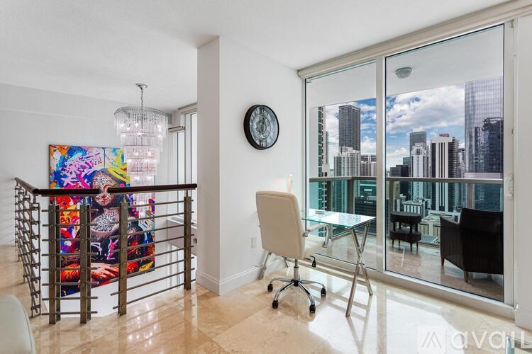 A room with a white chair and a painting on the wall.
