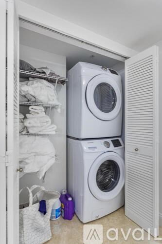 A white washing machine is in a small laundry room.