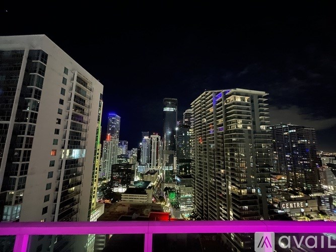 A cityscape at night with a pink line in the foreground.