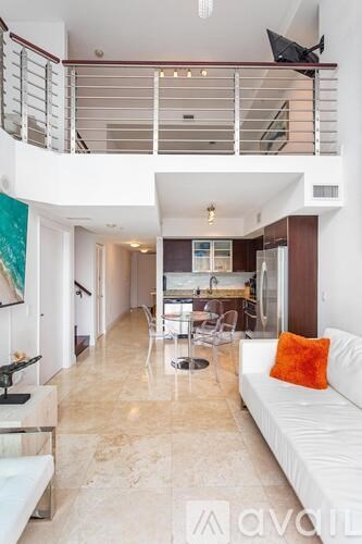 A living room with a white couch and a marble floor.