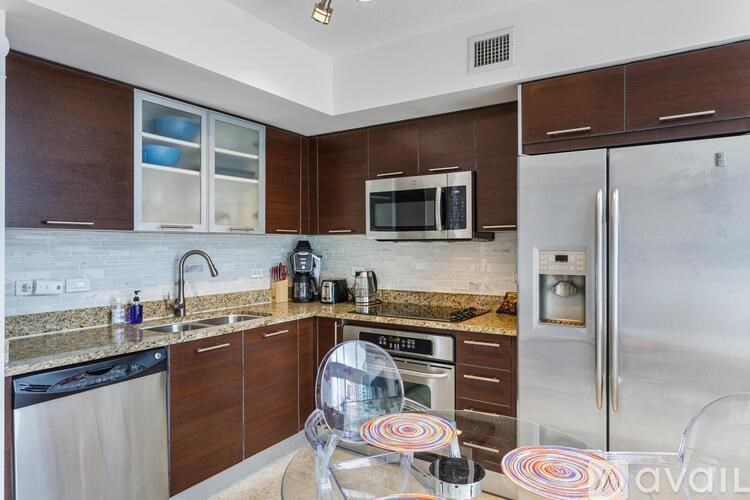 A kitchen with a refrigerator, microwave, and oven.