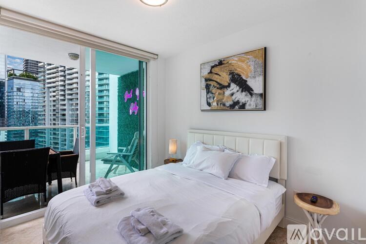 A bedroom with a large bed and a painting on the wall.