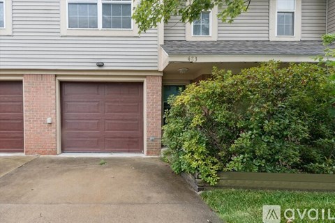 A two-story house with a garage door and a driveway.