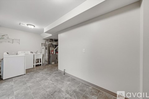 A kitchen with white cabinets and a black refrigerator.