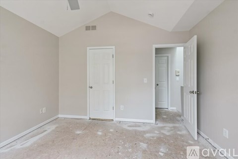 A room with two white doors and a ceiling fan.