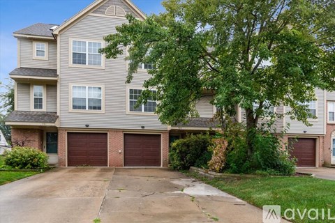 A two-story house with a garage and a driveway.
