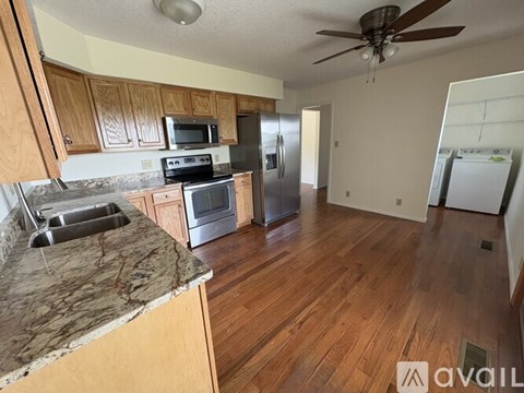 A kitchen with wooden cabinets and a marble countertop.