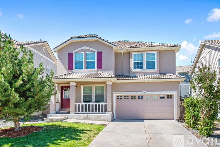 A house with a red door and a garage door is for sale.