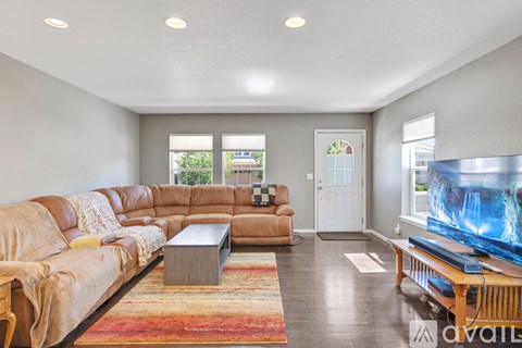 A living room with a large leather sofa and a coffee table.