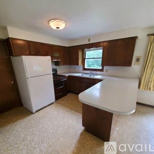 A kitchen with brown cabinets and a white refrigerator.