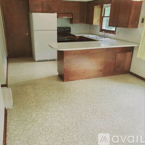 A kitchen with brown cabinets and a white fridge.