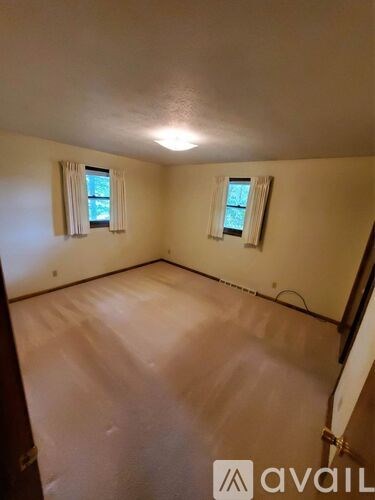 A room with a window and a wall-mounted light fixture.