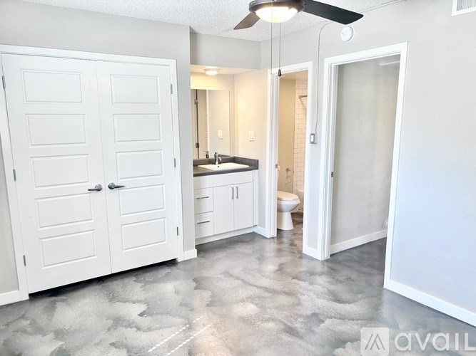 A white bathroom with a fan and a toilet.