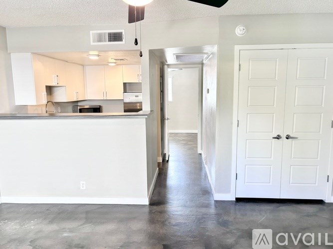 A kitchen with white cabinets and a countertop with a sink.