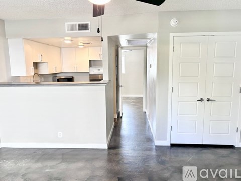 A kitchen with white cabinets and a countertop with a sink.